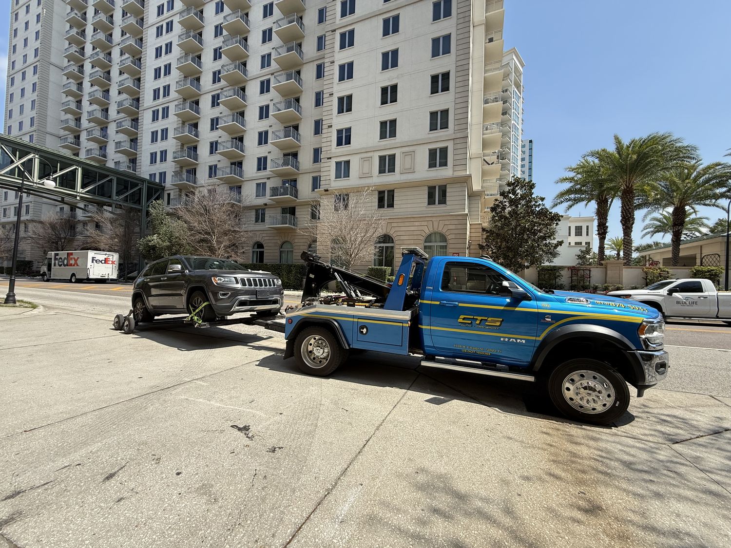 CTS self-loader towing a Jeep from a downtown property