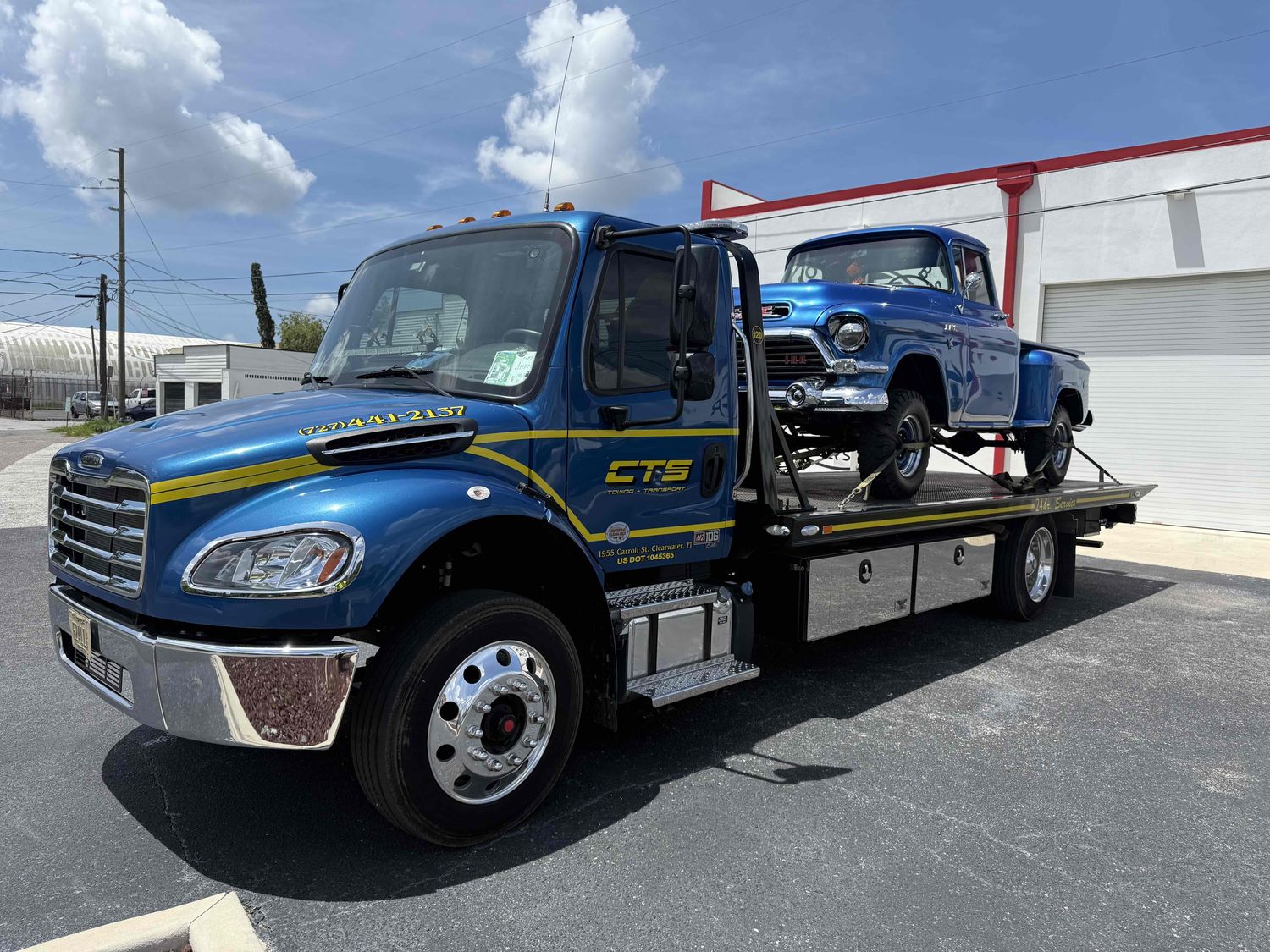 CTS flatbed towing a classic pickup in Tampa Bay